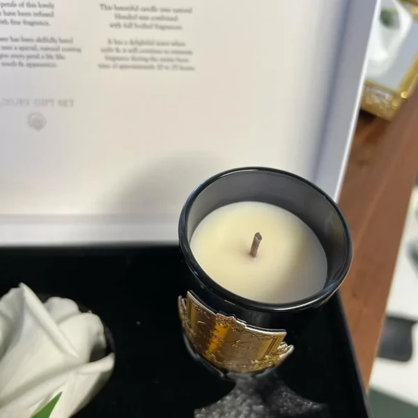 Vela perfumada Côte Noire em recipiente preto com base dourada, dentro da caixa de apresentação.